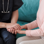 Profesional de la salud brindando apoyo y agarrando la mano de una mujer